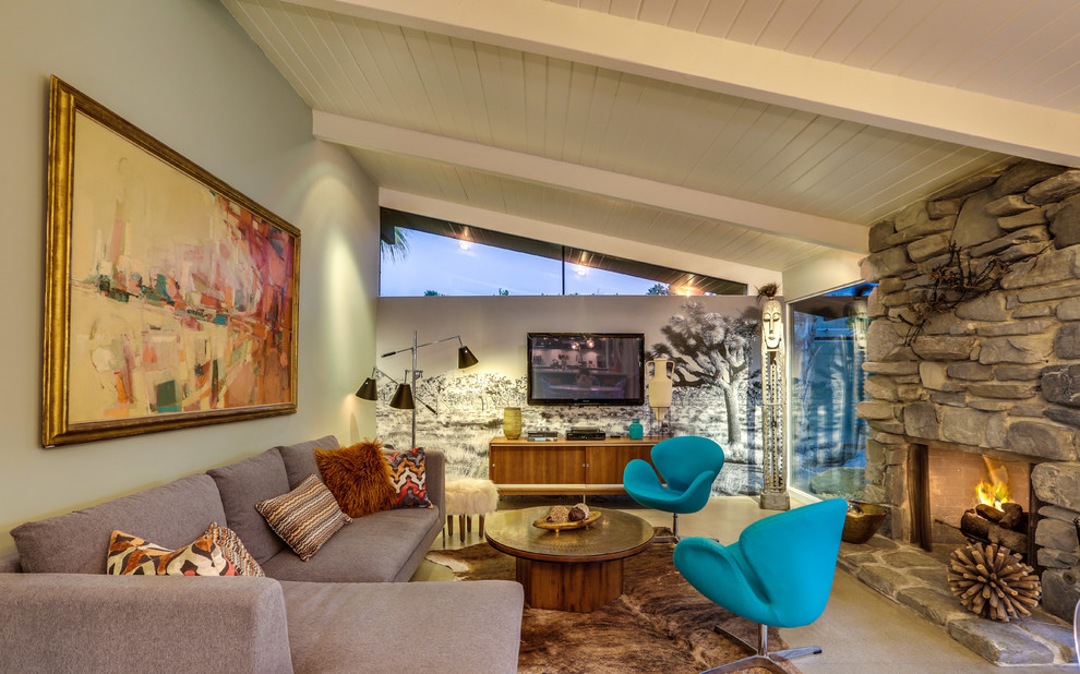 1950s family room photo in Los Angeles with green walls, a standard fireplace, a stone fireplace and a wall-mounted tv