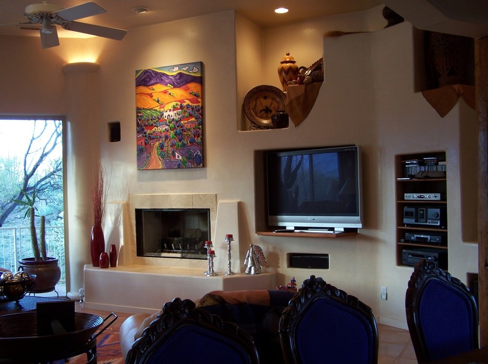 Mittelgroßes, Offenes Mediterranes Wohnzimmer mit beiger Wandfarbe, Terrakottaboden, Kamin, Kaminumrandung aus Stein und Multimediawand in Phoenix