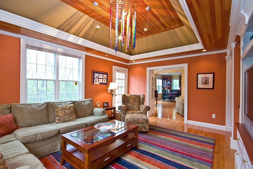 Esempio di un grande soggiorno tradizionale con pareti arancioni e parquet chiaro