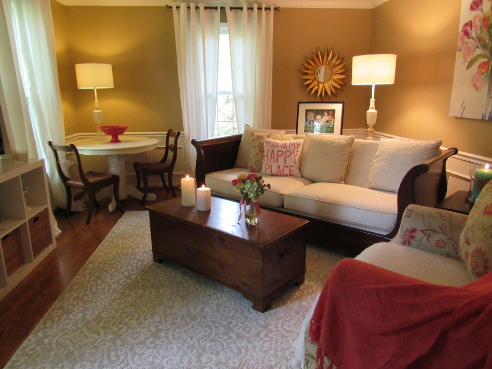 Immagine di un piccolo soggiorno classico chiuso con pareti beige, pavimento in legno massello medio, nessun camino e nessuna TV