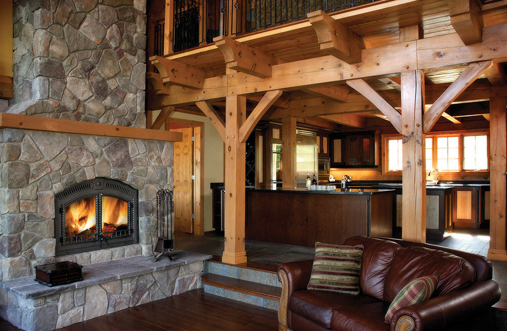 Example of a mid-sized mountain style enclosed dark wood floor and brown floor family room design in Toronto with a standard fireplace, a stone fireplace and no tv