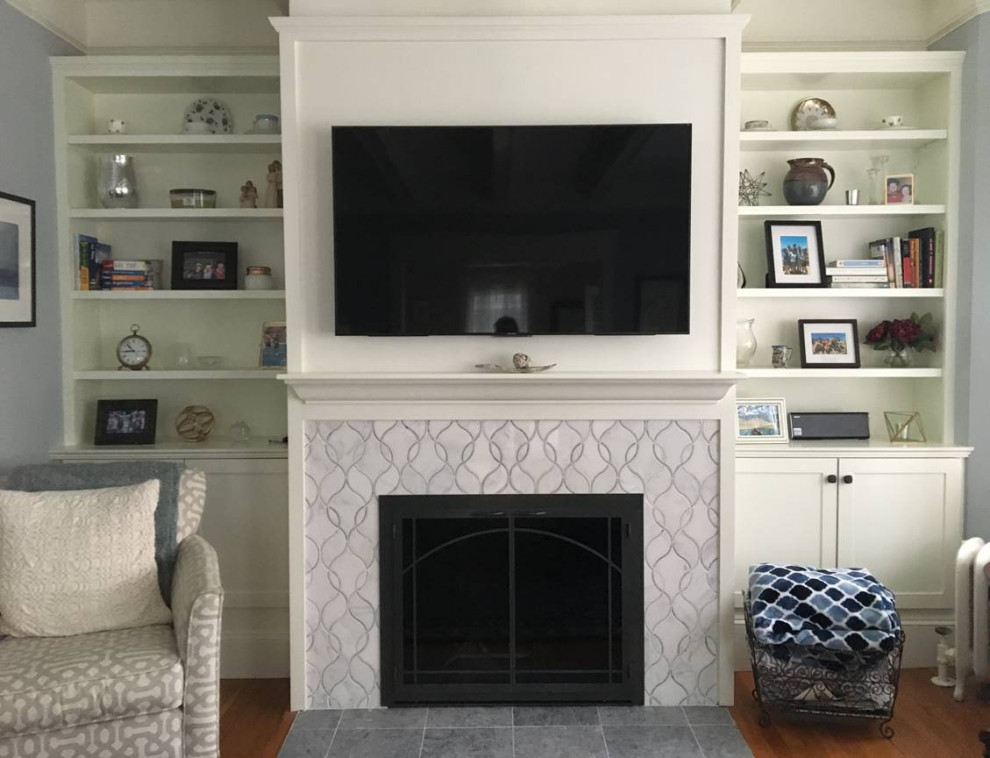 Mittelgroßes, Abgetrenntes Klassisches Wohnzimmer mit grauer Wandfarbe, braunem Holzboden, Kamin, gefliester Kaminumrandung, TV-Wand und braunem Boden in Boston