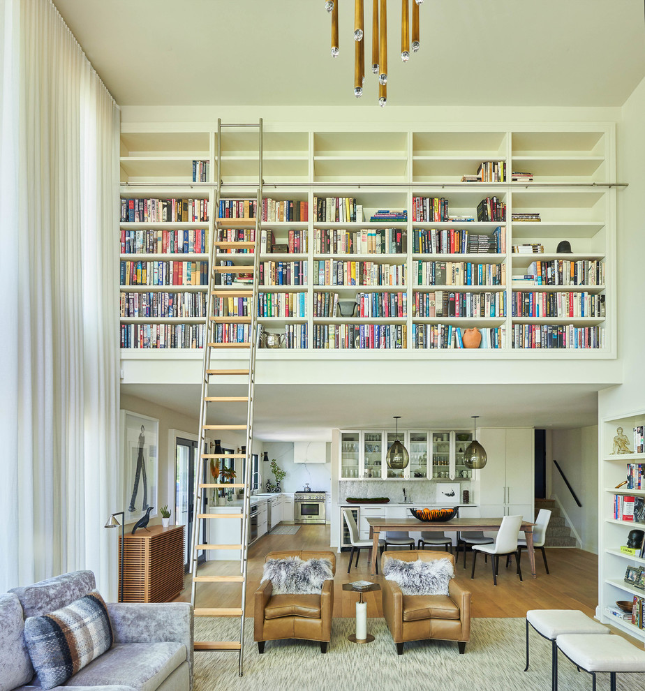 Esempio di un soggiorno design aperto con libreria, pareti bianche, pavimento in legno massello medio e pavimento marrone