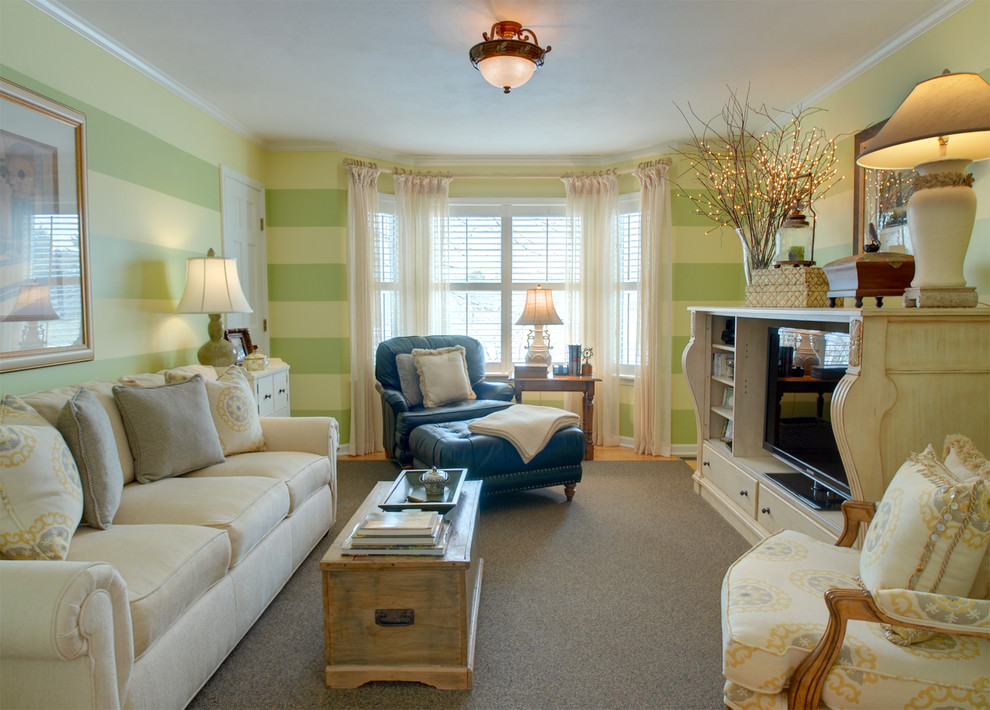 Immagine di un soggiorno classico chiuso con pareti verdi e TV autoportante