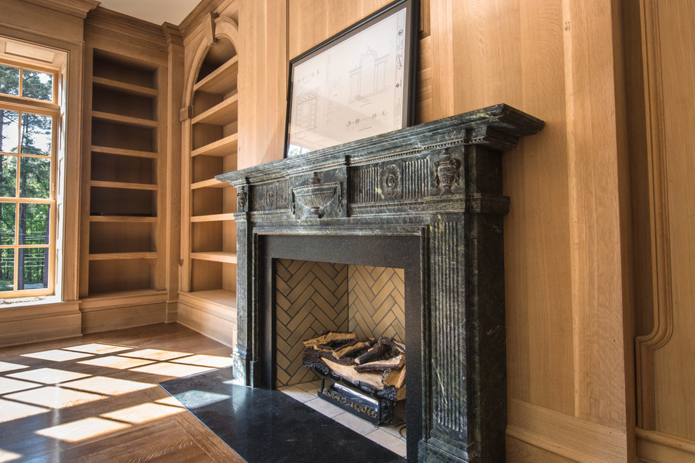 This is an example of a mediterranean games room in Raleigh with a standard fireplace and a stone fireplace surround.