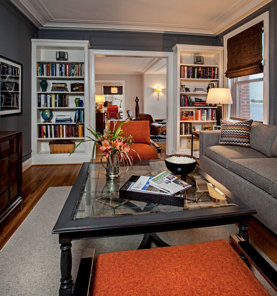 Ejemplo de sala de estar con biblioteca contemporánea con paredes grises, suelo de madera en tonos medios y televisor independiente