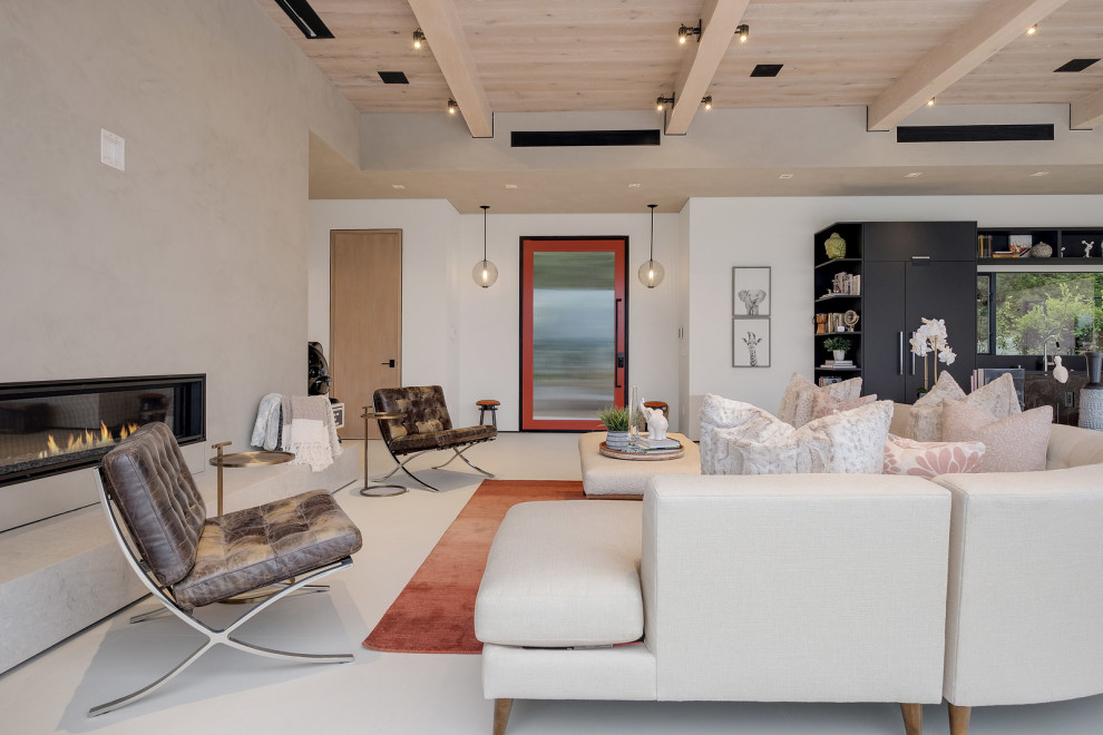 На фото: изолированная гостиная комната среднего размера в стиле модернизм с с книжными шкафами и полками, бежевыми стенами, стандартным камином, фасадом камина из кирпича, белым полом и деревянным потолком
