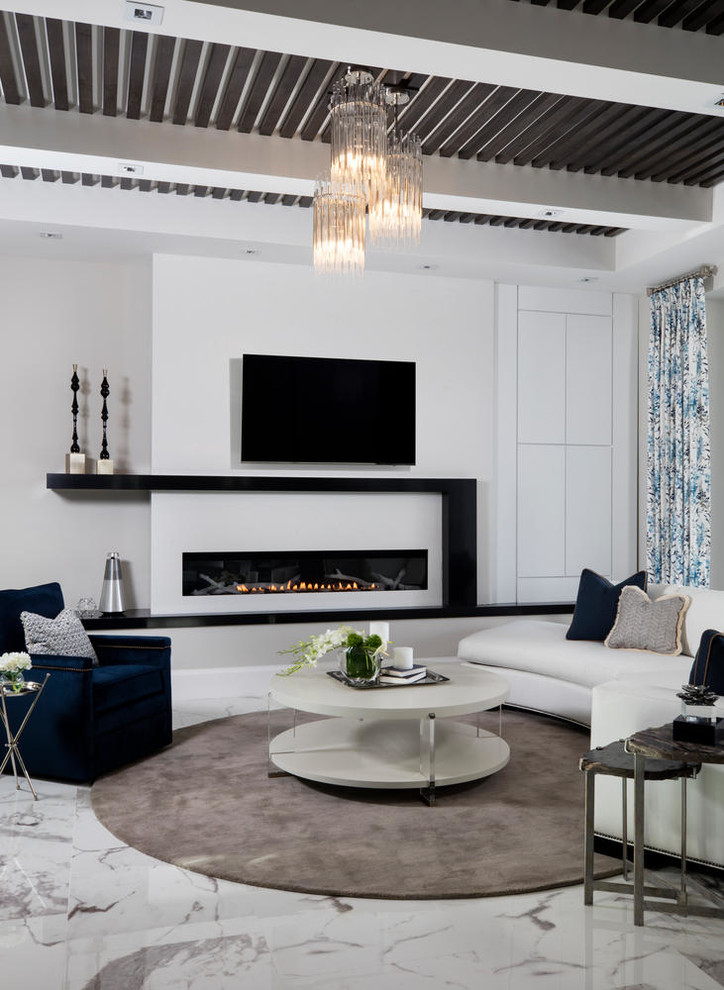 Diseño de sala de estar abierta actual grande con paredes blancas, suelo de mármol, todas las chimeneas, marco de chimenea de yeso, televisor colgado en la pared y suelo blanco