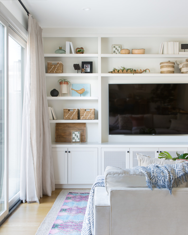 Cette photo montre une salle de séjour nature de taille moyenne et ouverte avec un mur blanc, parquet clair, un téléviseur encastré et un sol beige.