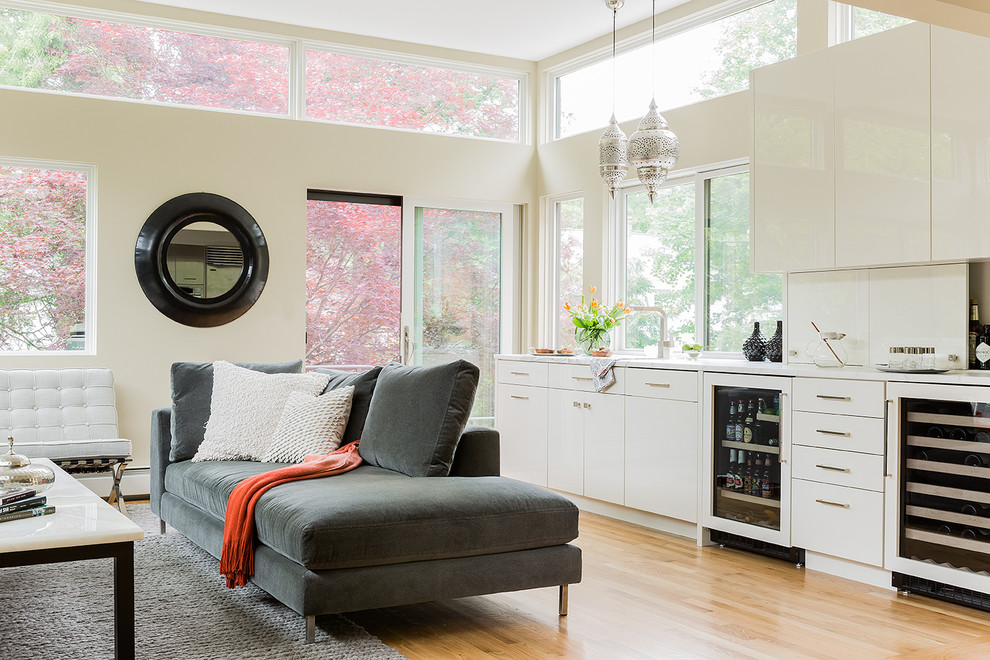 Foto de sala de estar con barra de bar contemporánea con paredes beige y suelo de madera clara
