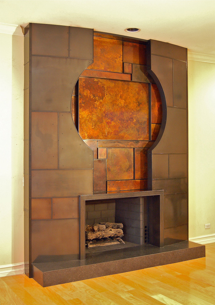 ロサンゼルスにあるコンテンポラリースタイルのおしゃれなファミリールーム (ベージュの壁、淡色無垢フローリング、標準型暖炉、金属の暖炉まわり) の写真