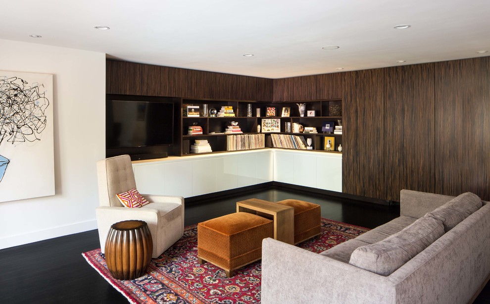На фото: гостиная комната в современном стиле с белыми стенами, темным паркетным полом и с книжными шкафами и полками без камина