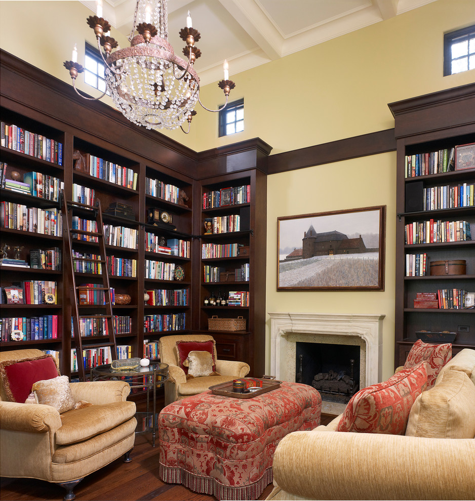 Foto de sala de estar con biblioteca mediterránea con todas las chimeneas y marco de chimenea de piedra