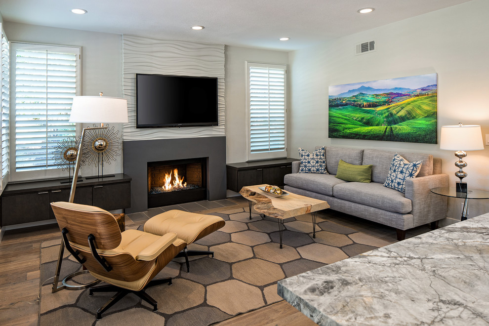 Свежая идея для дизайна: открытая гостиная комната среднего размера в современном стиле с светлым паркетным полом, стандартным камином, телевизором на стене и коричневым полом - отличное фото интерьера