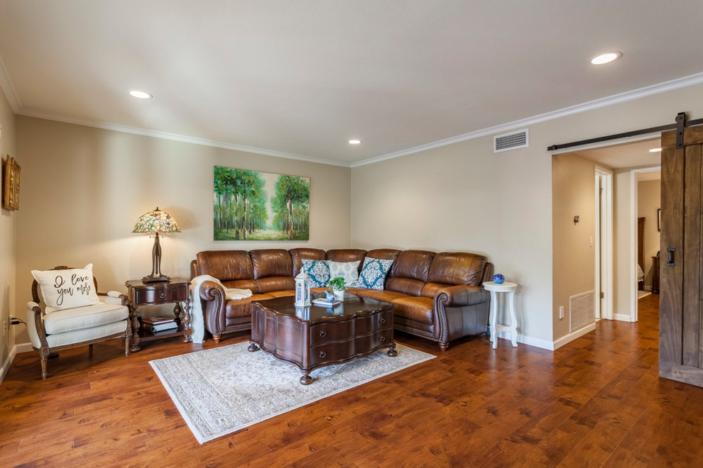 This is an example of a medium sized traditional enclosed games room in Los Angeles with a game room, beige walls, medium hardwood flooring, a concealed tv and brown floors.