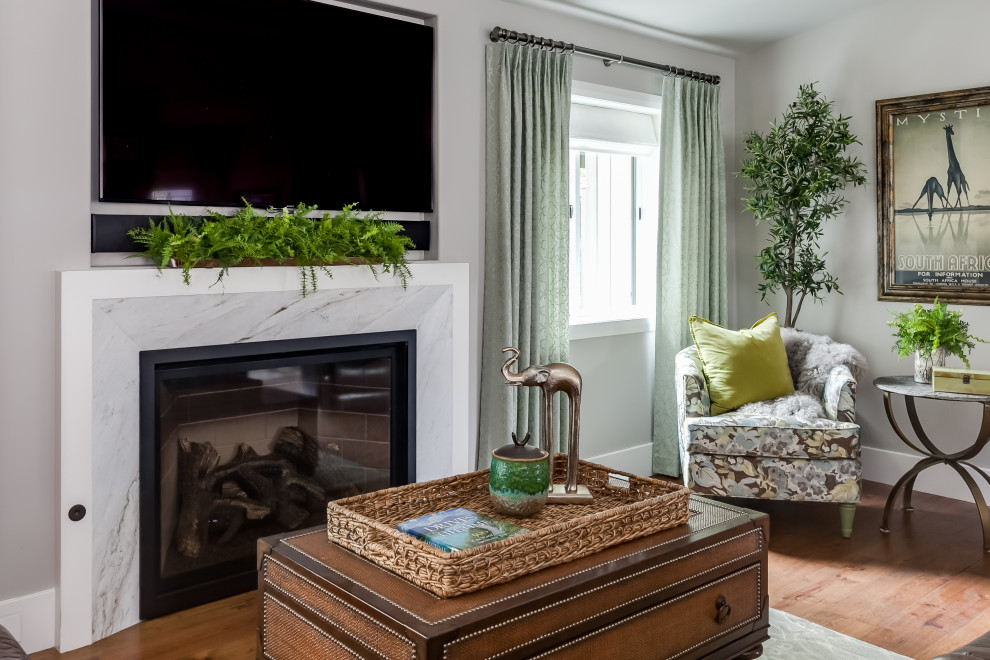 Imagen de sala de estar abierta tradicional pequeña con suelo de madera oscura, todas las chimeneas, marco de chimenea de piedra, televisor colgado en la pared y suelo marrón