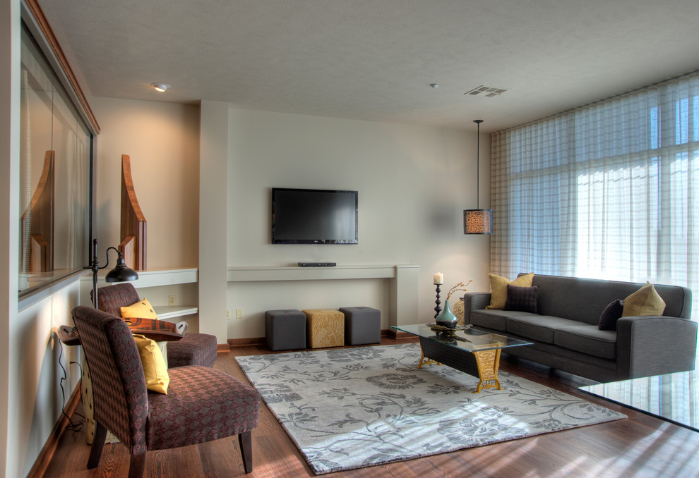 Mittelgroßes, Offenes Klassisches Wohnzimmer ohne Kamin mit beiger Wandfarbe, braunem Holzboden, TV-Wand und braunem Boden in Wichita