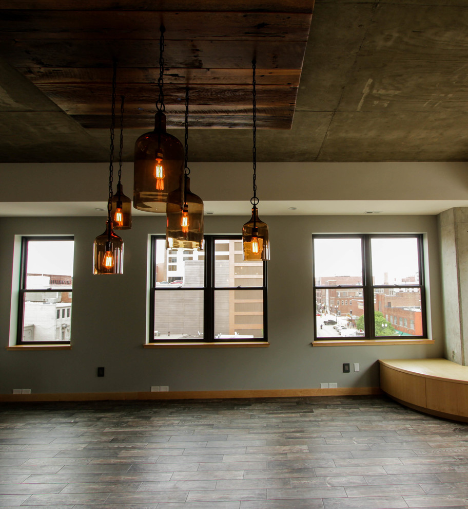 Modelo de sala de estar abierta actual grande sin televisor con paredes beige, suelo de madera oscura y suelo multicolor
