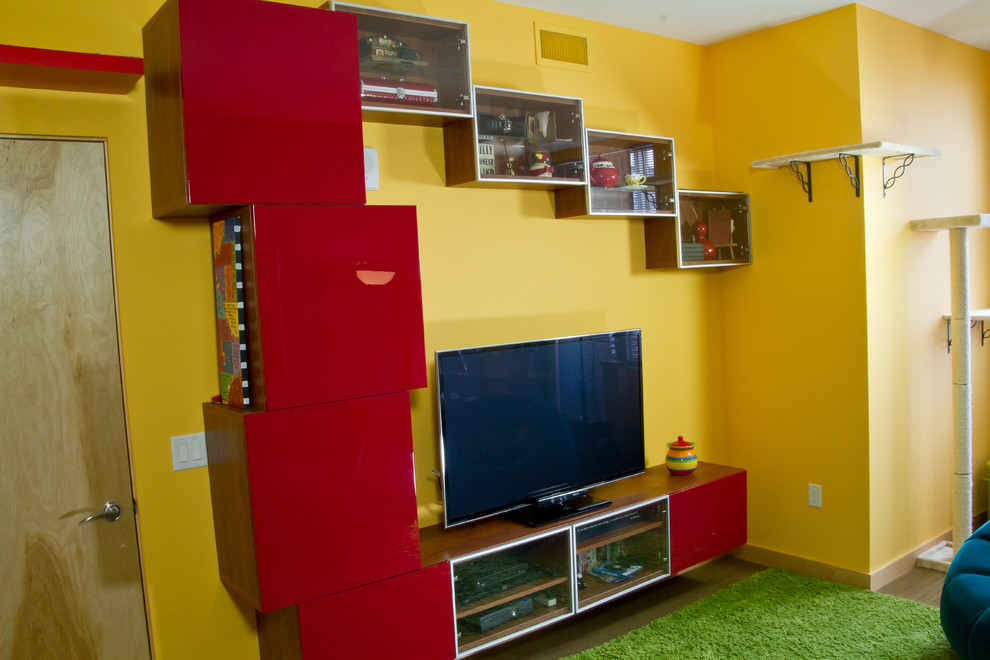 This is an example of a small eclectic enclosed games room in Milwaukee with yellow walls, light hardwood flooring and a freestanding tv.