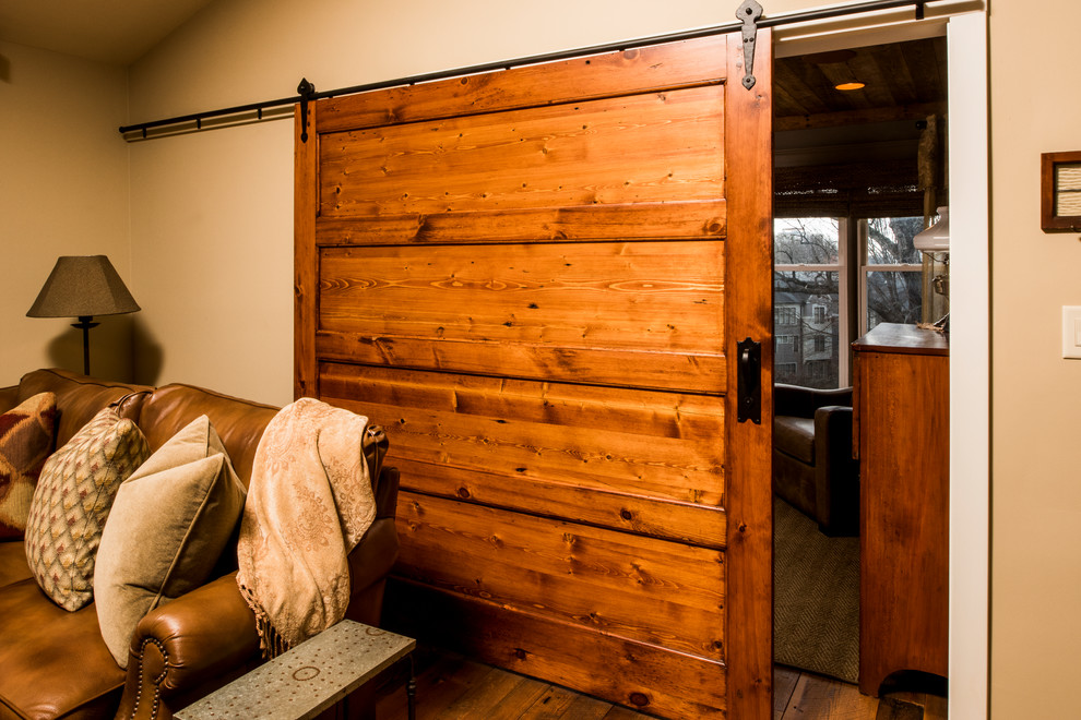 Exemple d'une salle de séjour montagne ouverte avec un mur beige, un sol en bois brun et un sol marron.