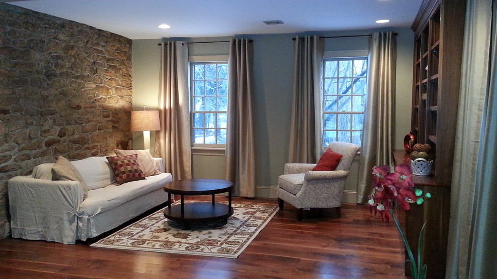 Foto de sala de estar tradicional renovada de tamaño medio sin chimenea con suelo de madera en tonos medios, pared multimedia y paredes grises