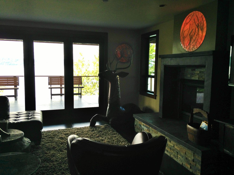 Example of a large eclectic enclosed concrete floor family room design in Seattle with beige walls, a two-sided fireplace and a stone fireplace