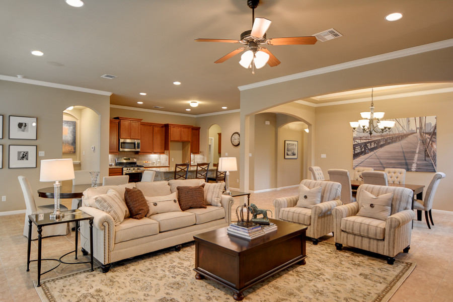 Modelo de sala de estar abierta de estilo americano grande sin chimenea con paredes beige y suelo de baldosas de cerámica