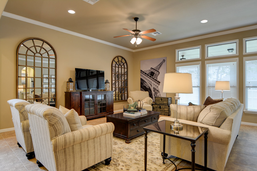 Foto de sala de estar abierta de estilo americano grande sin chimenea con paredes beige, suelo de baldosas de cerámica y televisor independiente