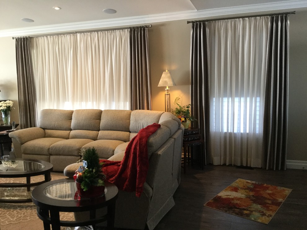 Imagen de sala de estar abierta clásica renovada de tamaño medio con paredes grises, suelo de madera en tonos medios y televisor colgado en la pared