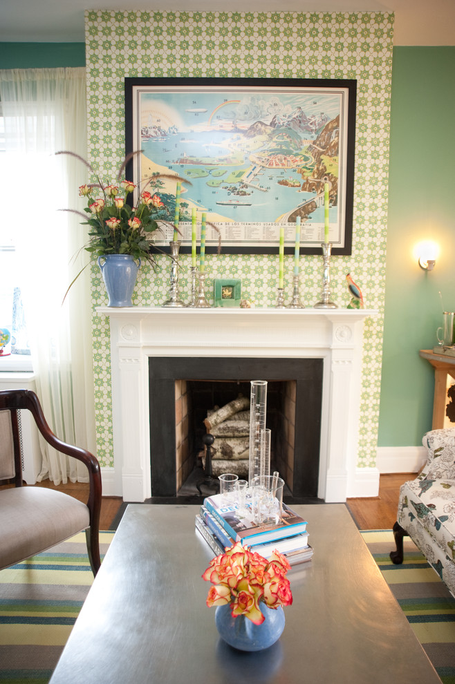 Immagine di un soggiorno tradizionale con pareti verdi, pavimento in legno massello medio e camino classico