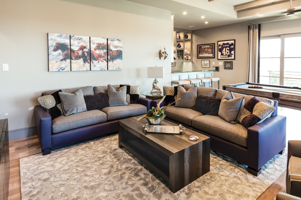 Foto de sala de estar con barra de bar cerrada tradicional renovada grande sin chimenea con paredes grises, suelo de madera en tonos medios y suelo marrón