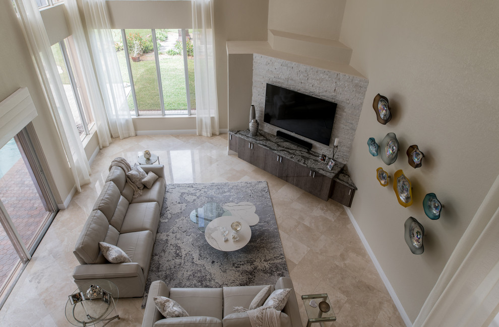 Diseño de sala de estar abierta actual de tamaño medio con paredes beige, suelo de travertino, televisor colgado en la pared y suelo beige