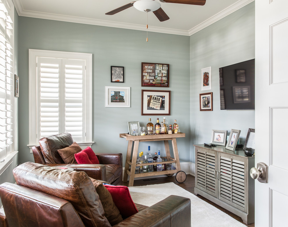 Cette image montre une petite salle de séjour traditionnelle avec un mur gris, parquet foncé et un téléviseur fixé au mur.