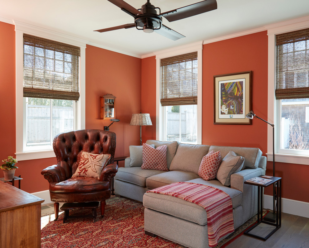 Idées déco pour une salle de séjour classique de taille moyenne et fermée avec un mur orange, un sol en bois brun et un téléviseur encastré.