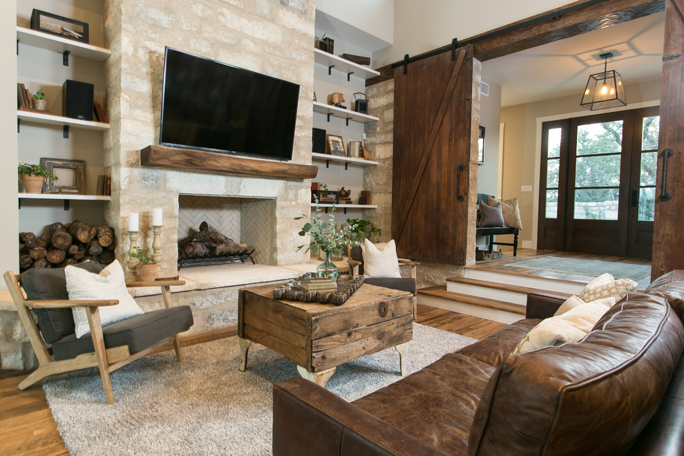 На фото: открытая гостиная комната в стиле кантри с бежевыми стенами, паркетным полом среднего тона, стандартным камином, фасадом камина из камня, телевизором на стене и ковром на полу