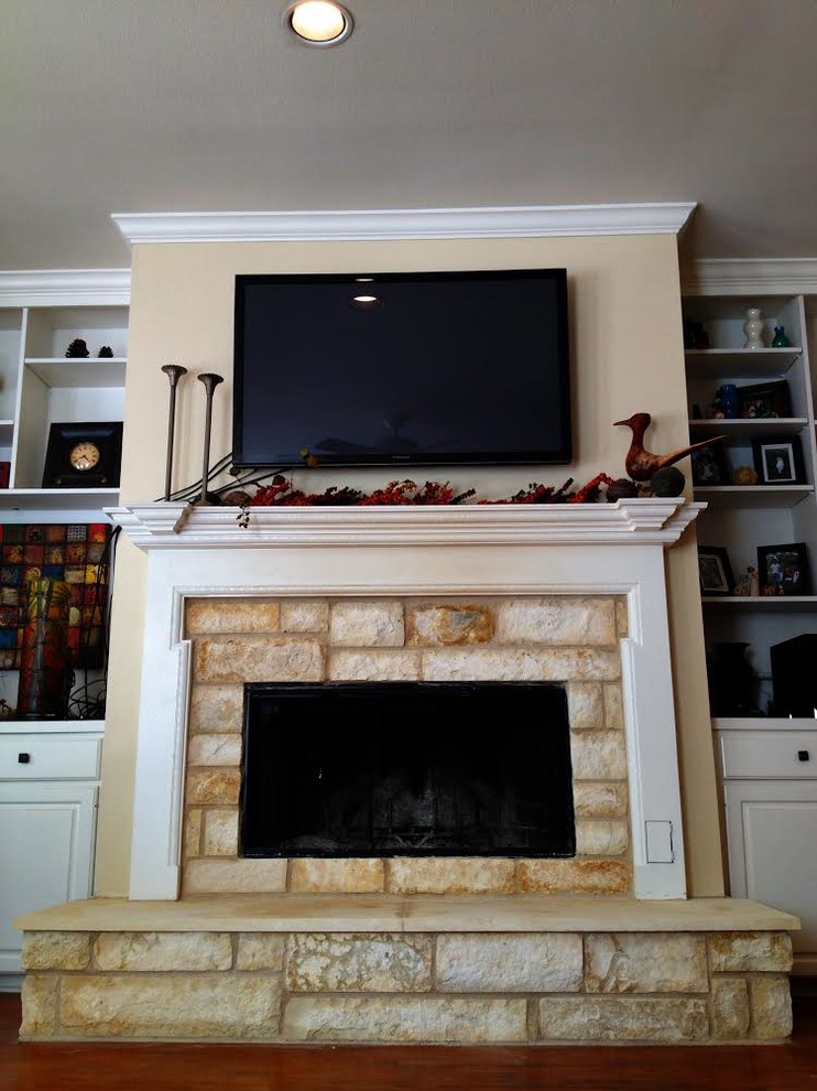 This is an example of a medium sized rustic enclosed games room in Austin with beige walls, dark hardwood flooring, a standard fireplace, a wooden fireplace surround and a wall mounted tv.