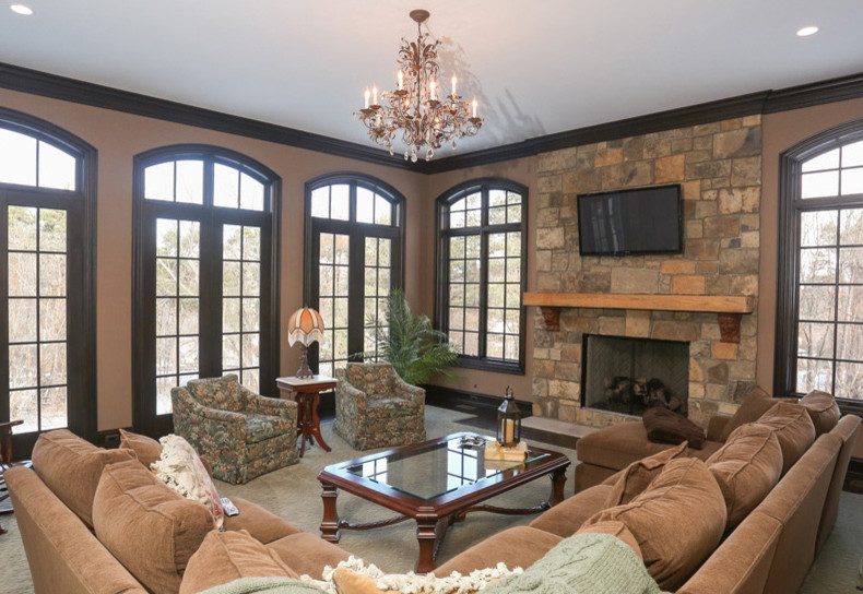 Foto de sala de estar rural grande con paredes marrones, moqueta, televisor colgado en la pared y suelo beige