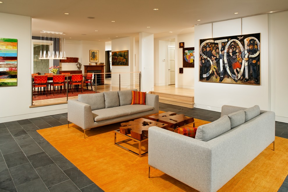 Пример оригинального дизайна: изолированная гостиная комната среднего размера в стиле неоклассика (современная классика) с белыми стенами, полом из сланца, стандартным камином, фасадом камина из камня и серым полом без телевизора
