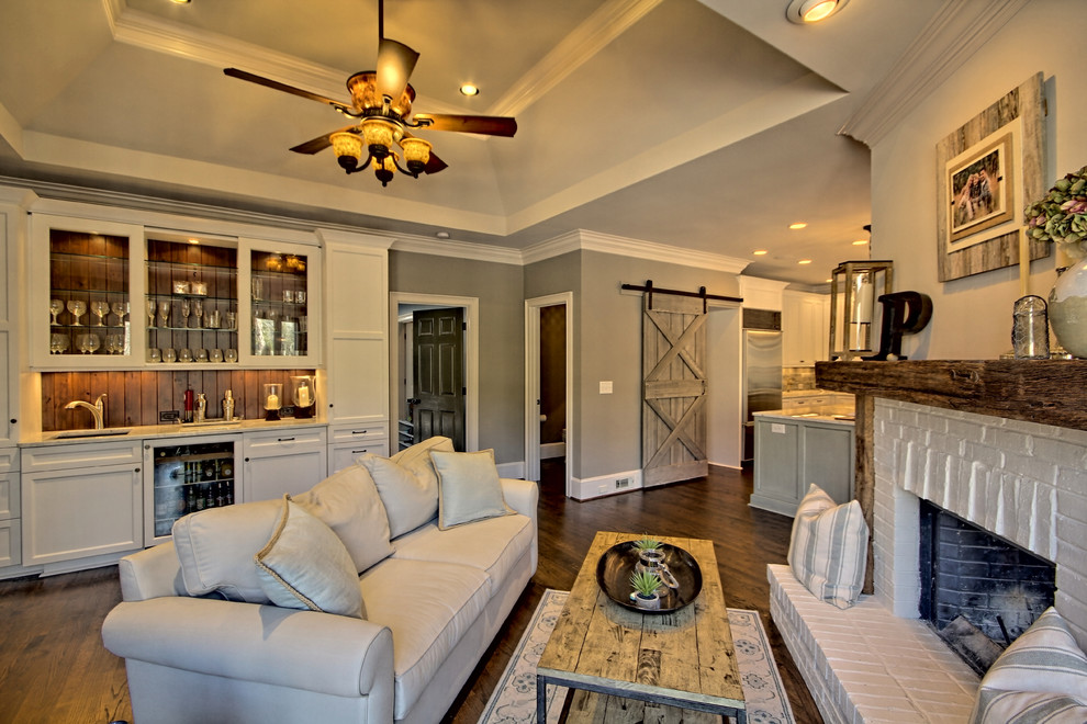 Example of a transitional dark wood floor family room design in Atlanta with gray walls and a brick fireplace