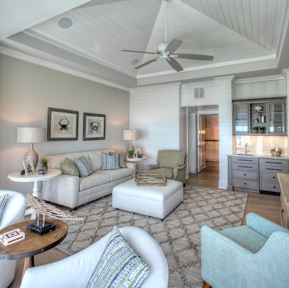 Idee per un soggiorno stile marino chiuso con pareti grigie, pavimento in legno massello medio, pavimento marrone e tappeto