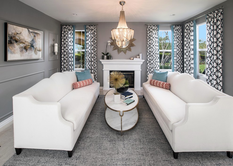 Example of a mid-sized transitional enclosed marble floor and beige floor family room design in Orange County with gray walls, a standard fireplace, a plaster fireplace and no tv