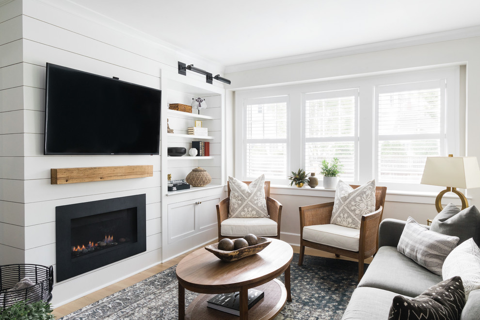 Kleines, Offenes Klassisches Wohnzimmer mit weißer Wandfarbe, braunem Holzboden, Kamin, Kaminumrandung aus Holz und TV-Wand in Boston