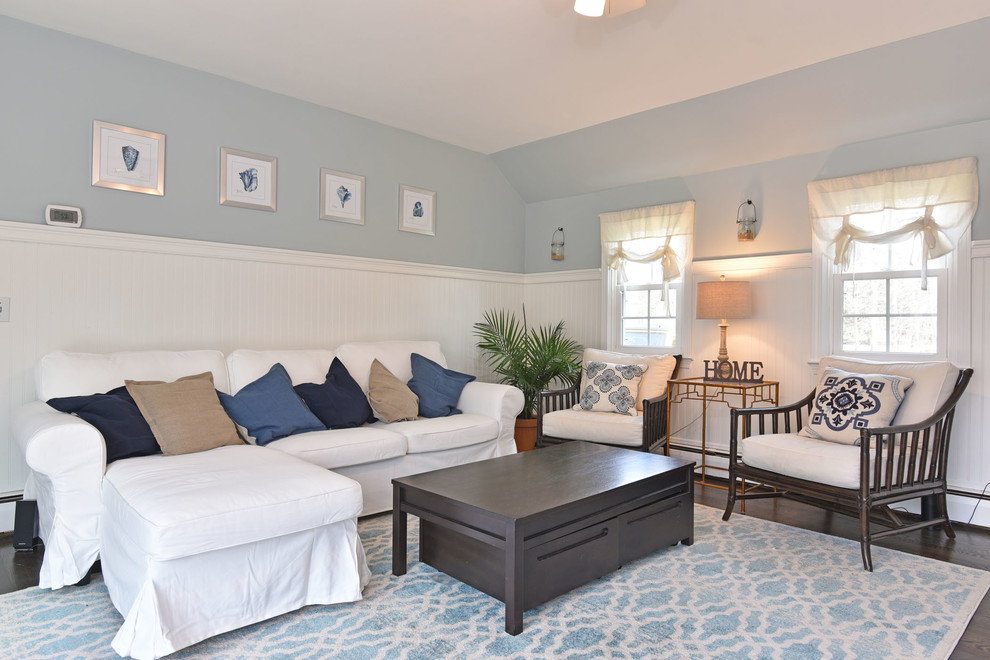 Пример оригинального дизайна: большая изолированная гостиная комната в морском стиле с синими стенами, паркетным полом среднего тона, стандартным камином, фасадом камина из кирпича, телевизором на стене и черным полом