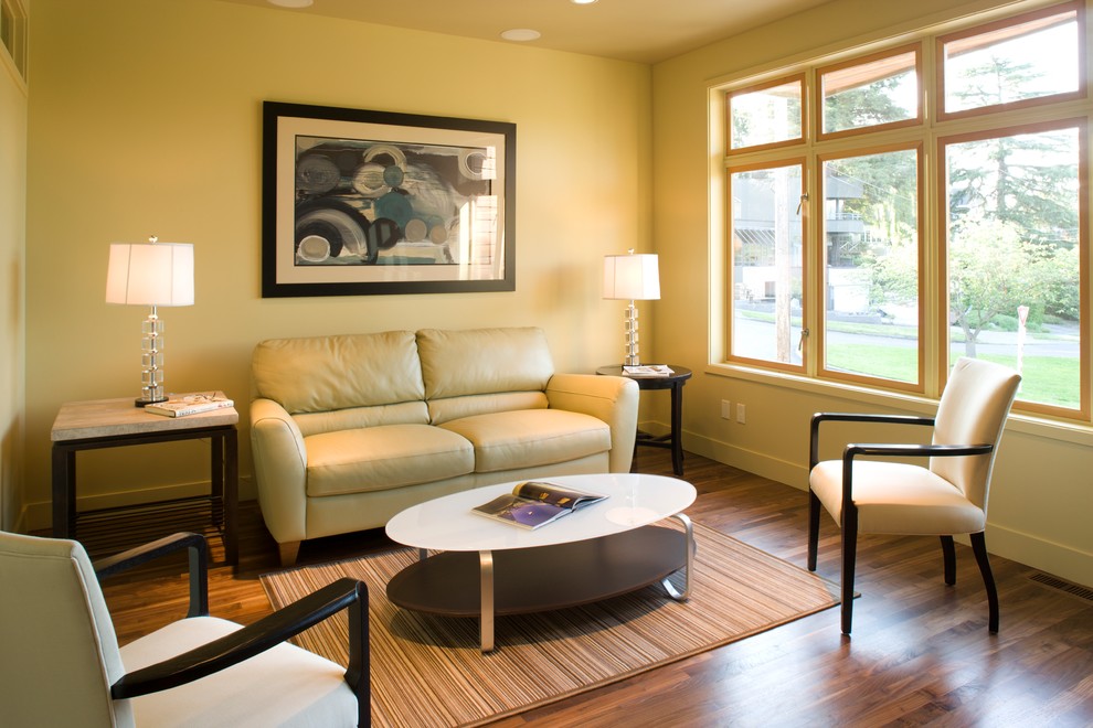 Imagen de sala de estar contemporánea sin televisor con paredes beige y suelo de madera oscura