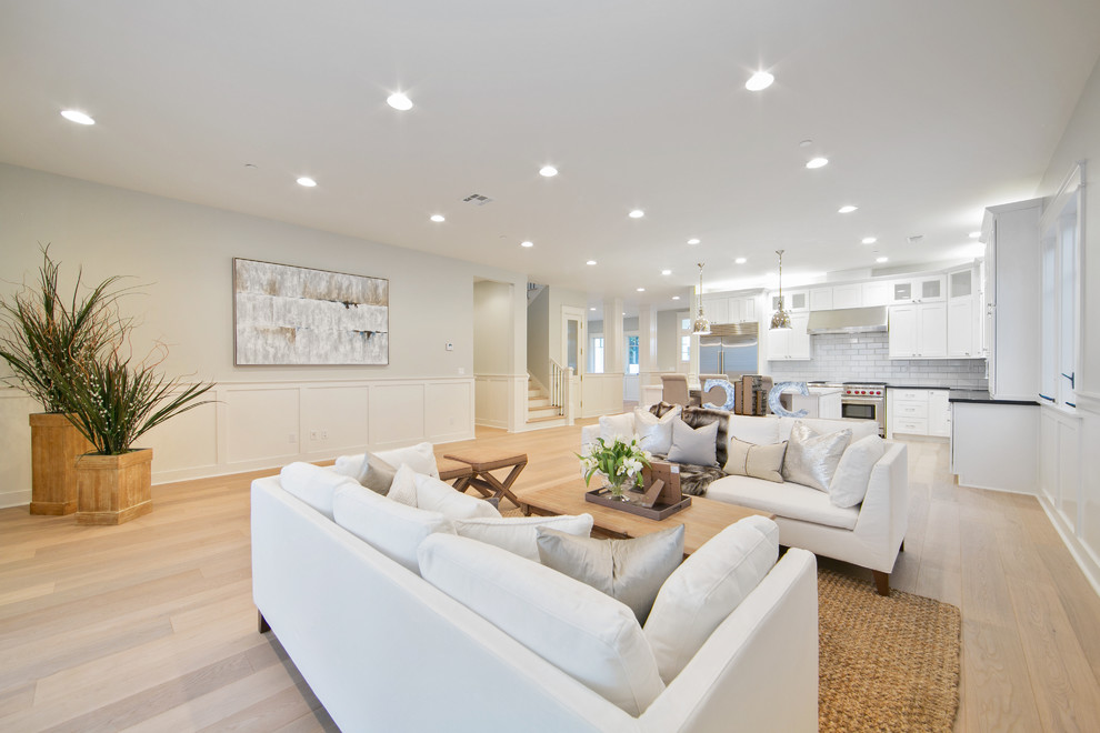 Ejemplo de sala de estar abierta clásica renovada de tamaño medio con paredes blancas, suelo de madera clara, suelo beige y alfombra