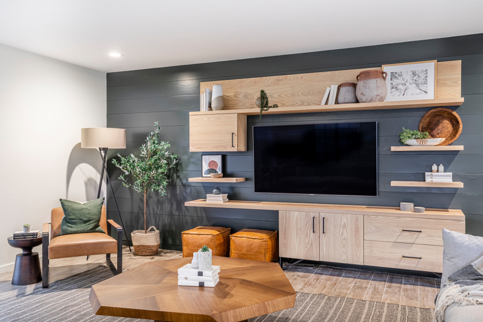 На фото: изолированная гостиная комната среднего размера в современном стиле с телевизором на стене, серыми стенами, коричневым полом, стенами из вагонки и акцентной стеной с