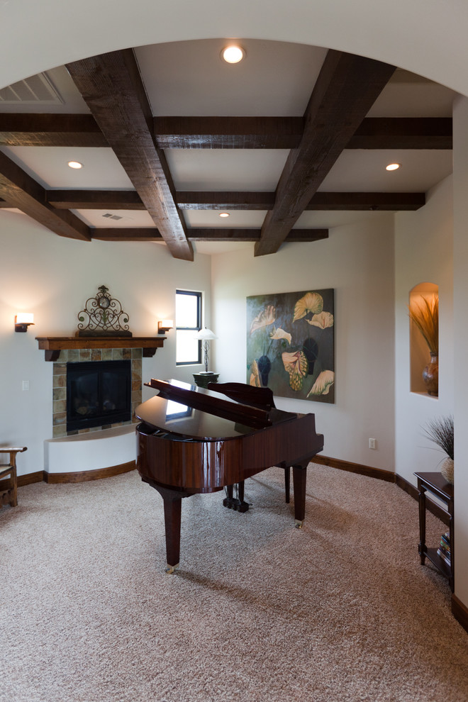 Photo of a medium sized mediterranean enclosed games room in San Luis Obispo with a music area, white walls, carpet, a standard fireplace, a stone fireplace surround, no tv and beige floors.