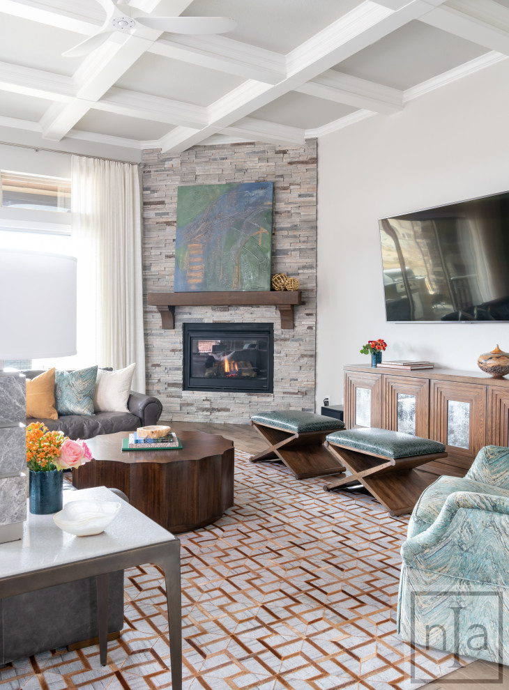 На фото: изолированная гостиная комната в стиле неоклассика (современная классика) с серыми стенами, паркетным полом среднего тона, стандартным камином, телевизором на стене, коричневым полом, фасадом камина из кирпича и кессонным потолком