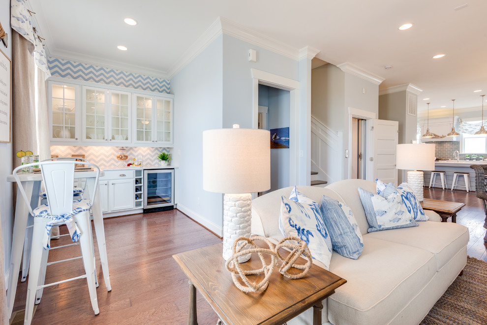 Ejemplo de sala de estar abierta marinera grande con paredes azules, suelo de madera en tonos medios y pared multimedia