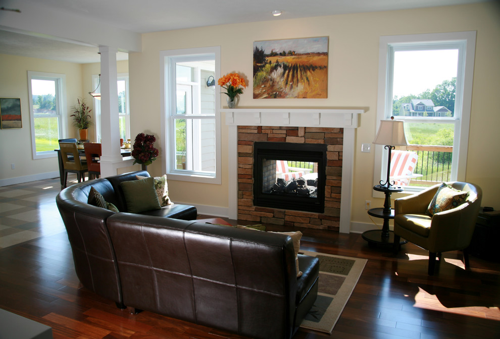 This is an example of a medium sized classic open plan games room in Other with beige walls, dark hardwood flooring, a two-sided fireplace and a stone fireplace surround.